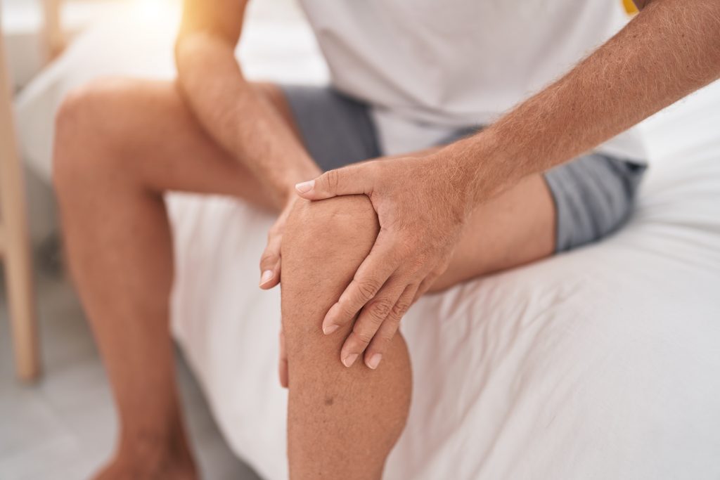 Man holding painful knee injury
